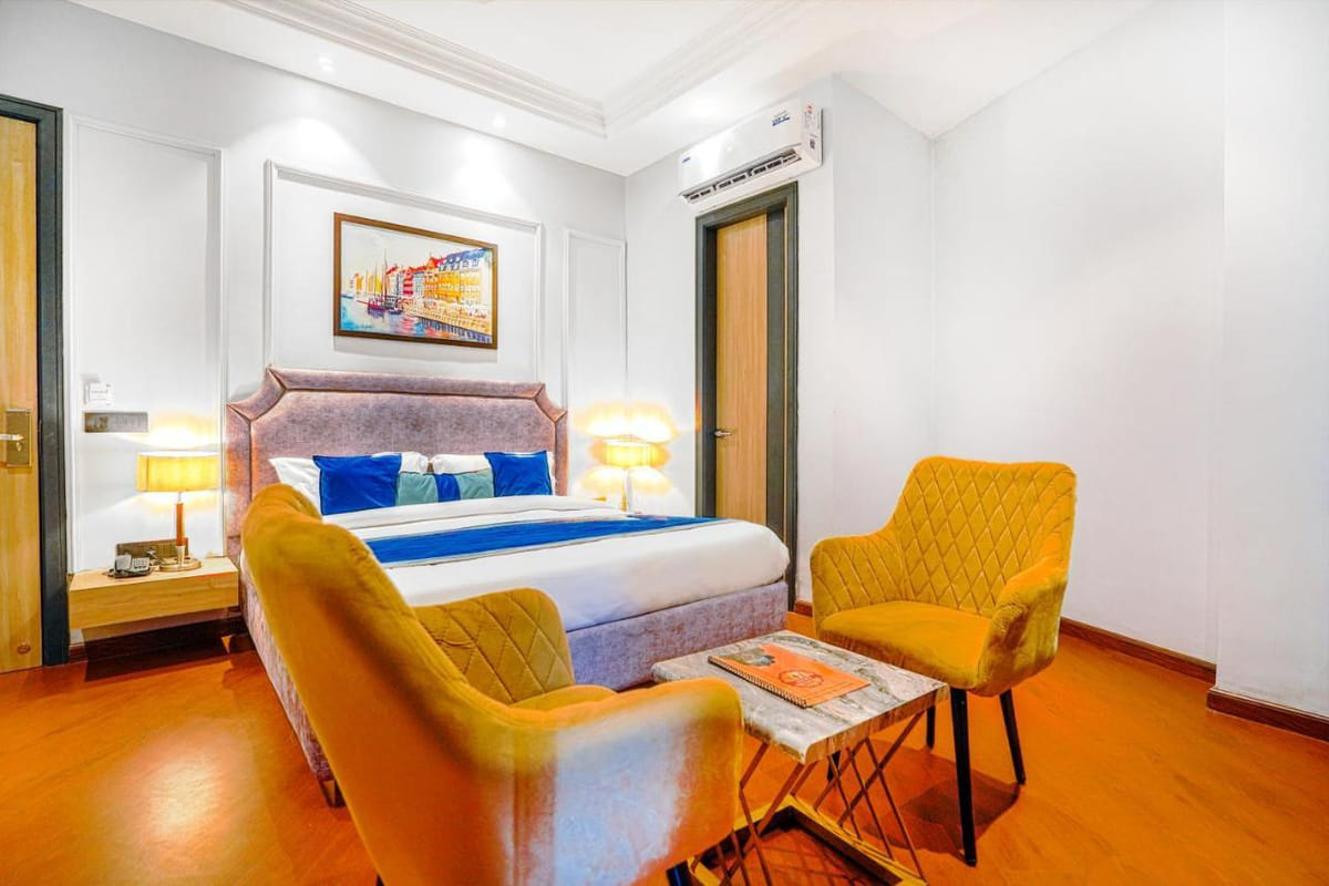 A Super Deluxe room at Grand Cabbana, with a grey padded headboard, blue and white cushions