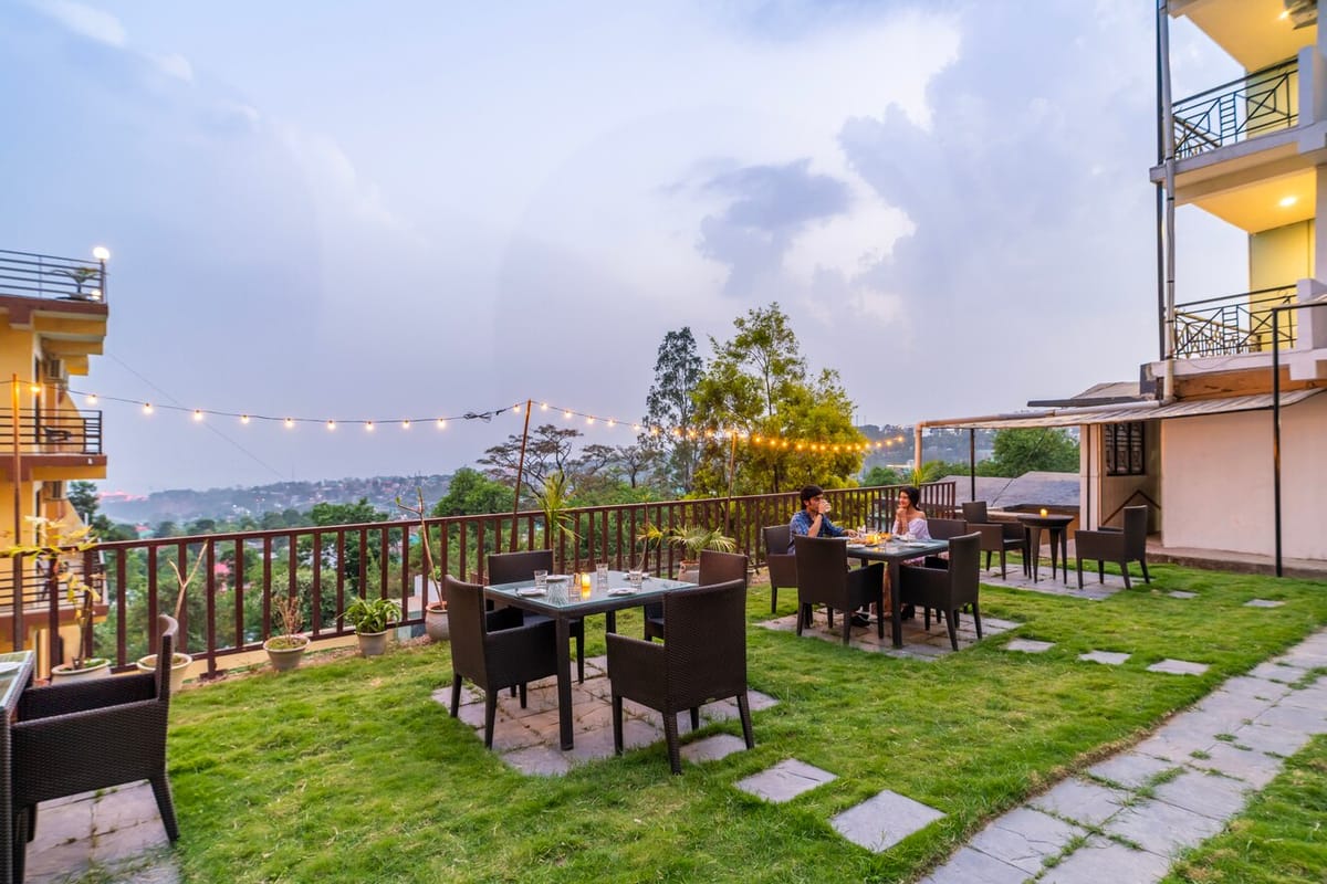 Outdoor dining on the lawn at Hotel Karnika, with tables and chairs set under strings of lights