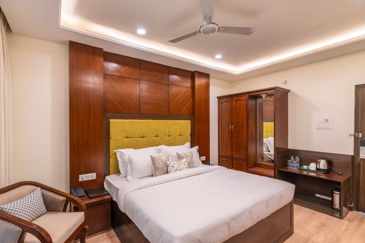 A Standard room with mountain view at Hotel Karnika, with a yellow padded headboard, a wardrobe