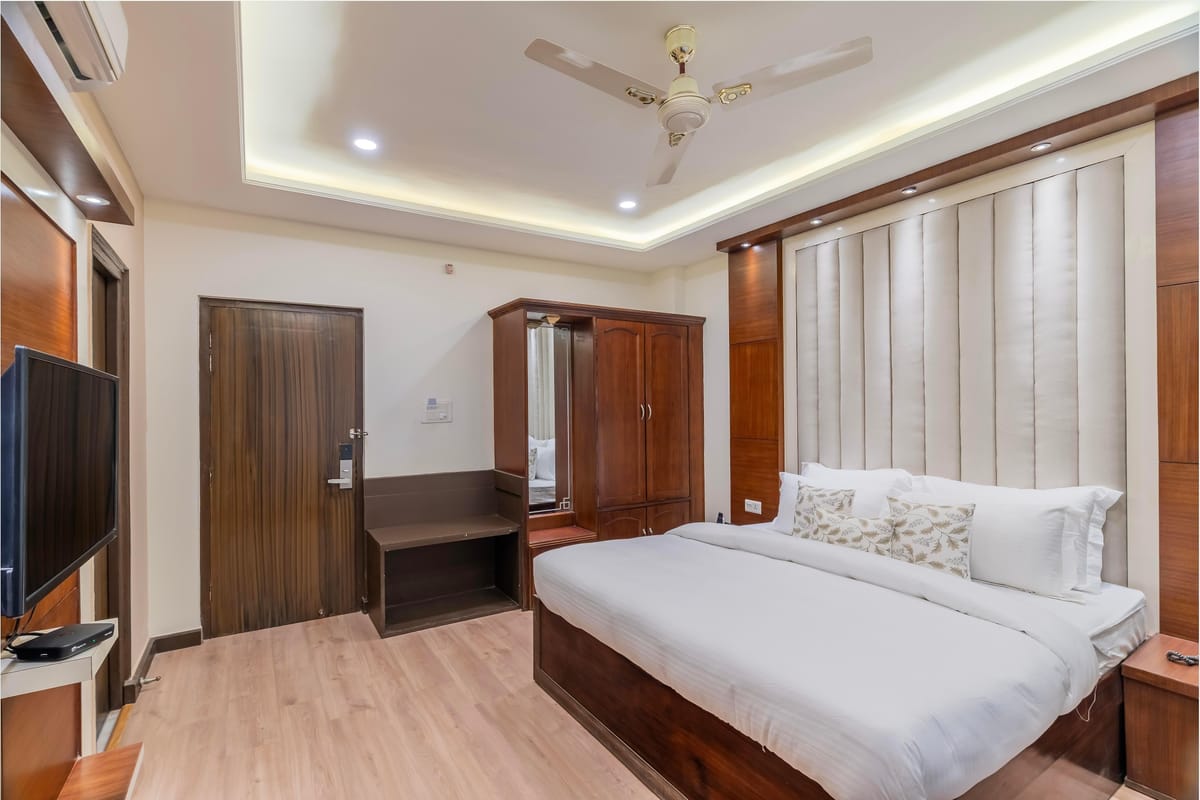 A Standard room with mountain view at Hotel Karnika, with a fluted headboard panel, a television opposite