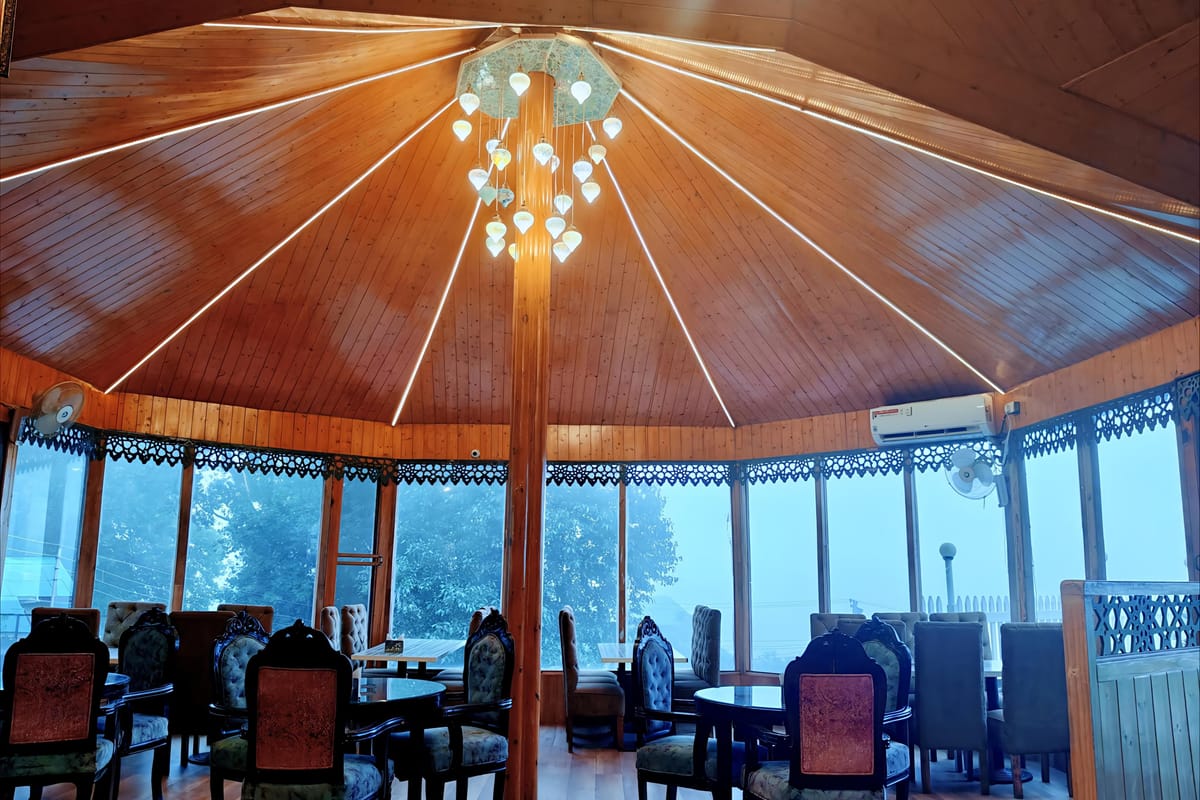 The restaurant at Levelup The Heritage Kud, a circular glass-walled room with a timber ceiling radiating from the chandelier