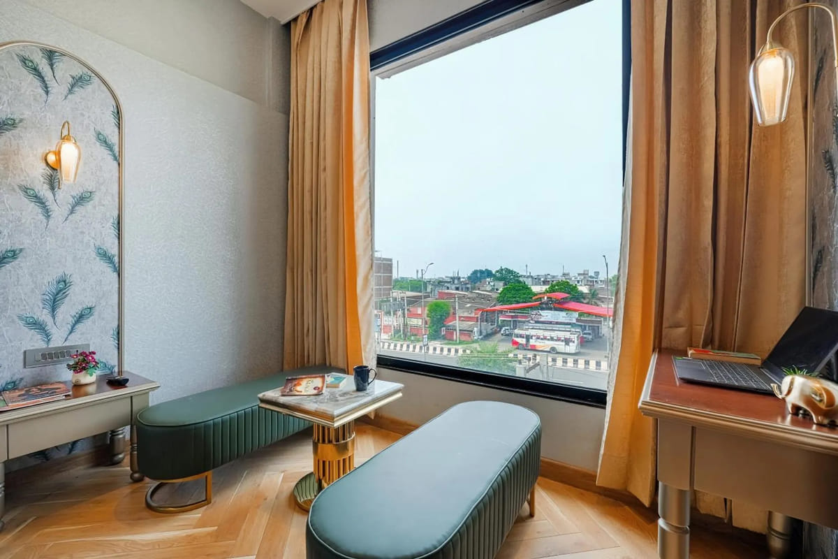 The window seating nook in a Suite at Marrion Hotel, with two green upholstered benches and a small table looking out