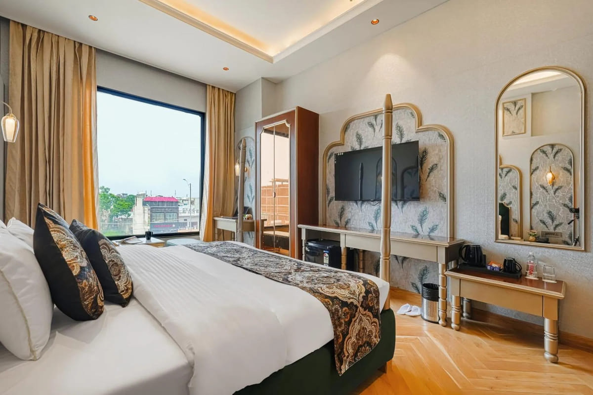 A Suite at Marrion Hotel, with a king bed facing a floor-to-ceiling window over the city, gold curtains