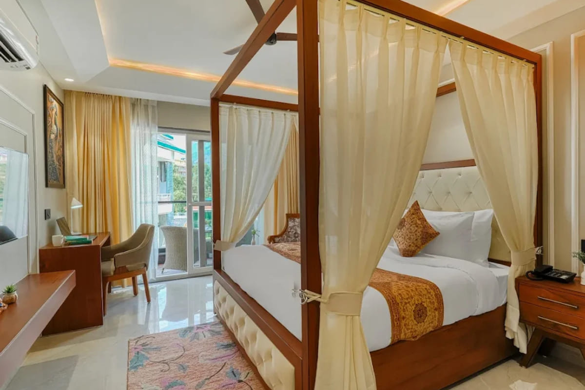 The Couple Suite Room at White Panda Hotel Divine Peaks, with a draped four-poster bed, a tufted headboard