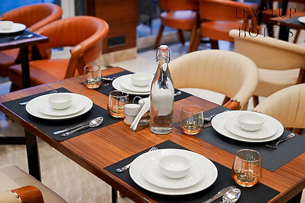 A table laid for a meal at the restaurant in White Panda Hotel Divine Peaks, with plates, glasses