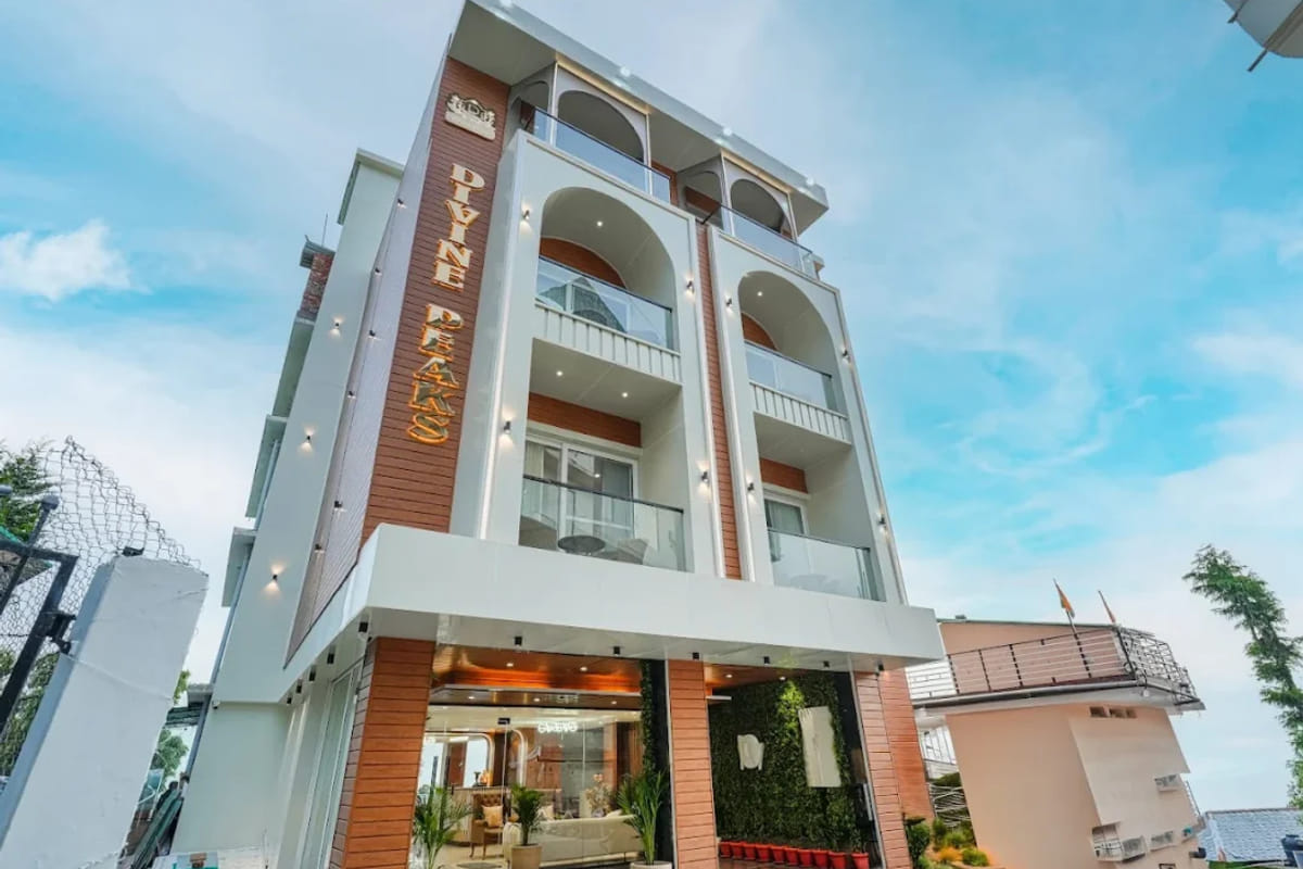 The white multi-storey exterior of White Panda Hotel Divine Peaks in Naddi, its balconies stacked above the entrance