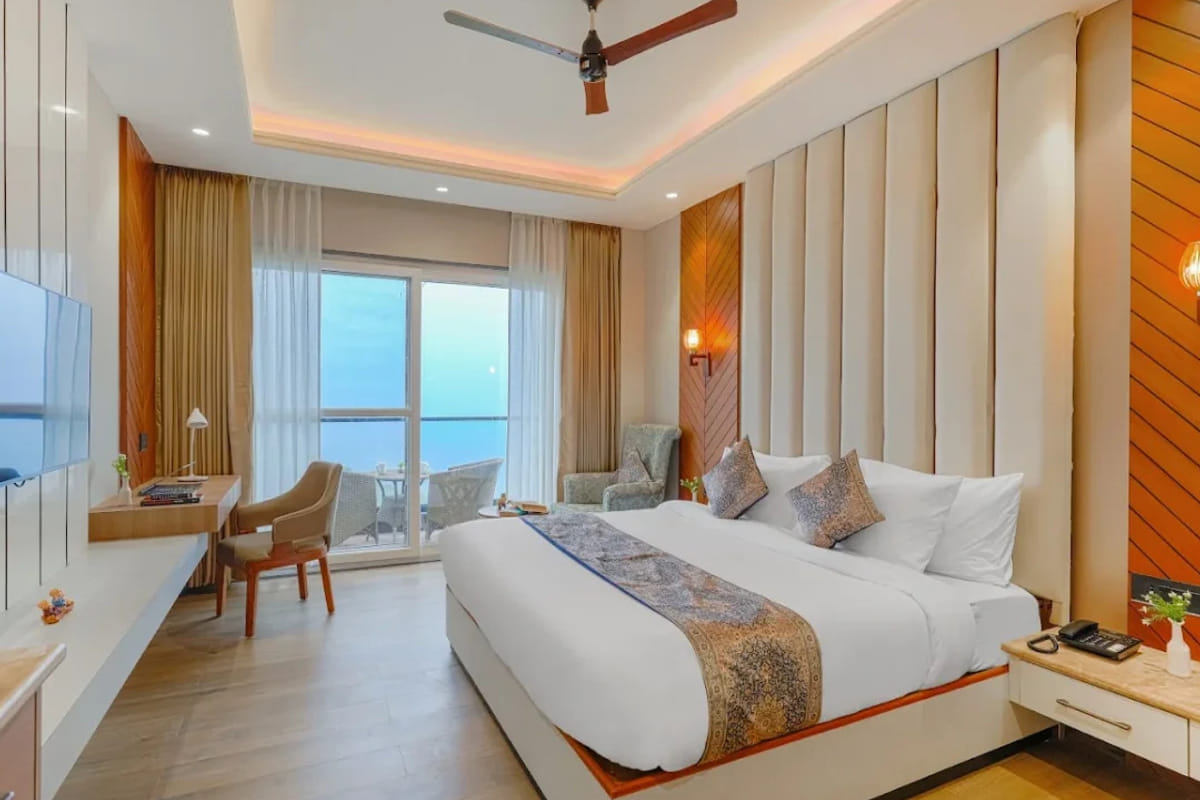 The Premium Room with Balcony at White Panda Hotel Divine Peaks, with the bed against fluted panelling and a table