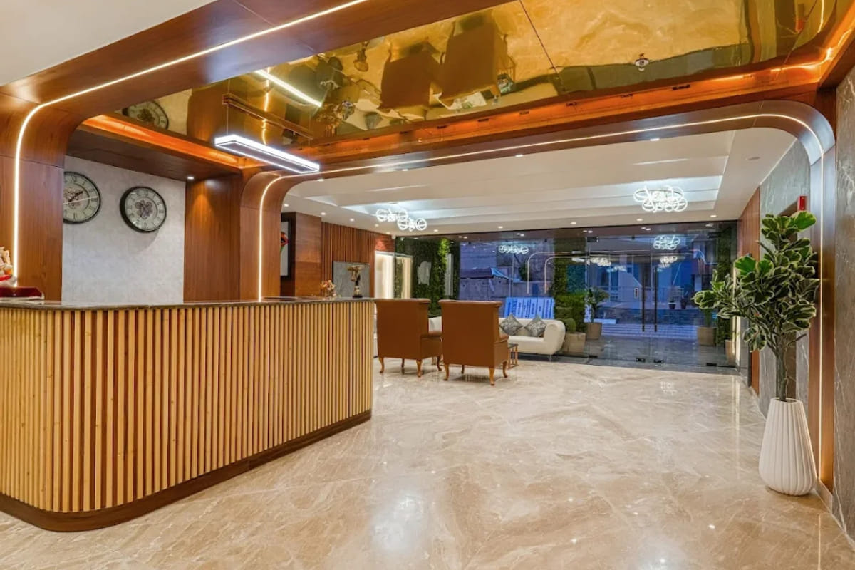 The reception at White Panda Hotel Divine Peaks, with a curved timber counter, a row of wall clocks above it