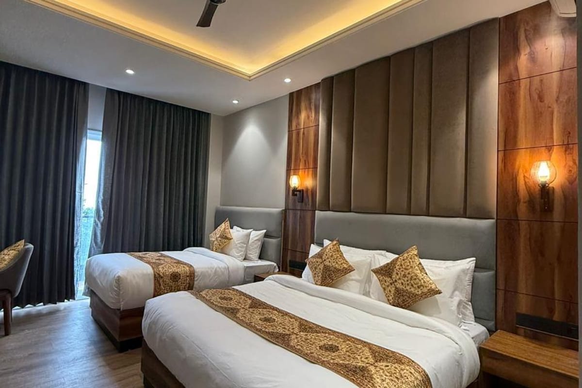 A guest room at White Panda Hotel Divine Peaks, with two beds under gold runners