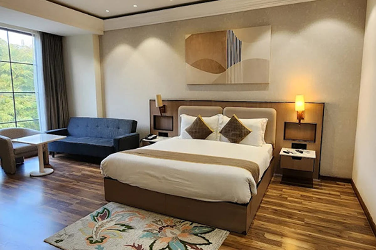 Guest room with a king bed and window seating at a White Panda hotel