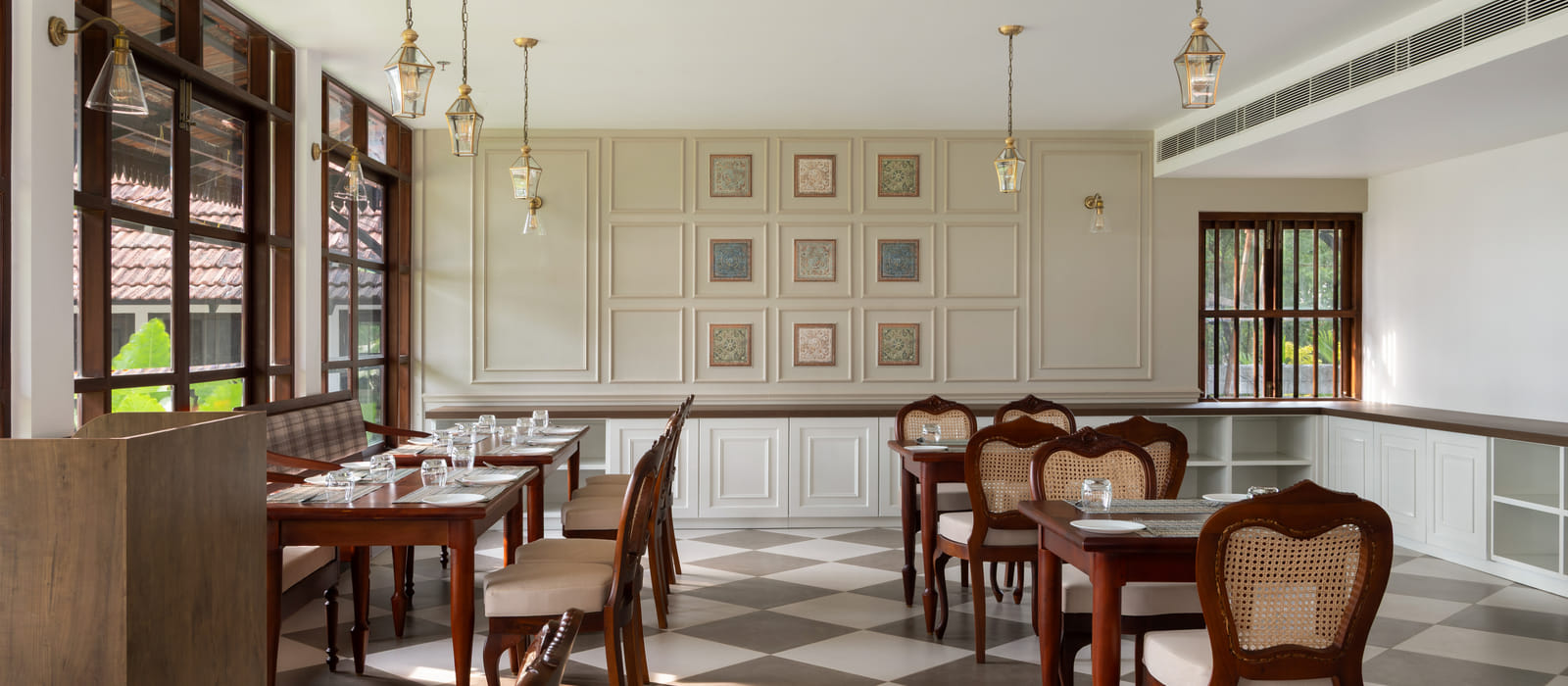 The Lilly's dining hall set for a meal with wood tables, chairs and dark ceiling beams, Sanskreti