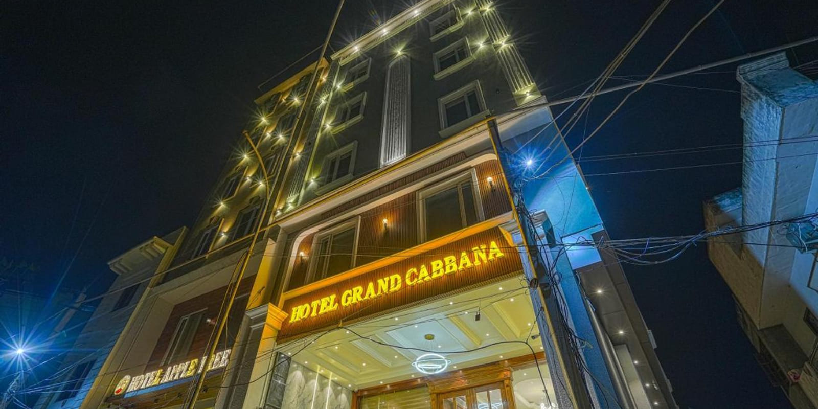 Grand Cabbana in Amritsar lit at night, its illuminated signage above the entrance on a tall narrow frontage