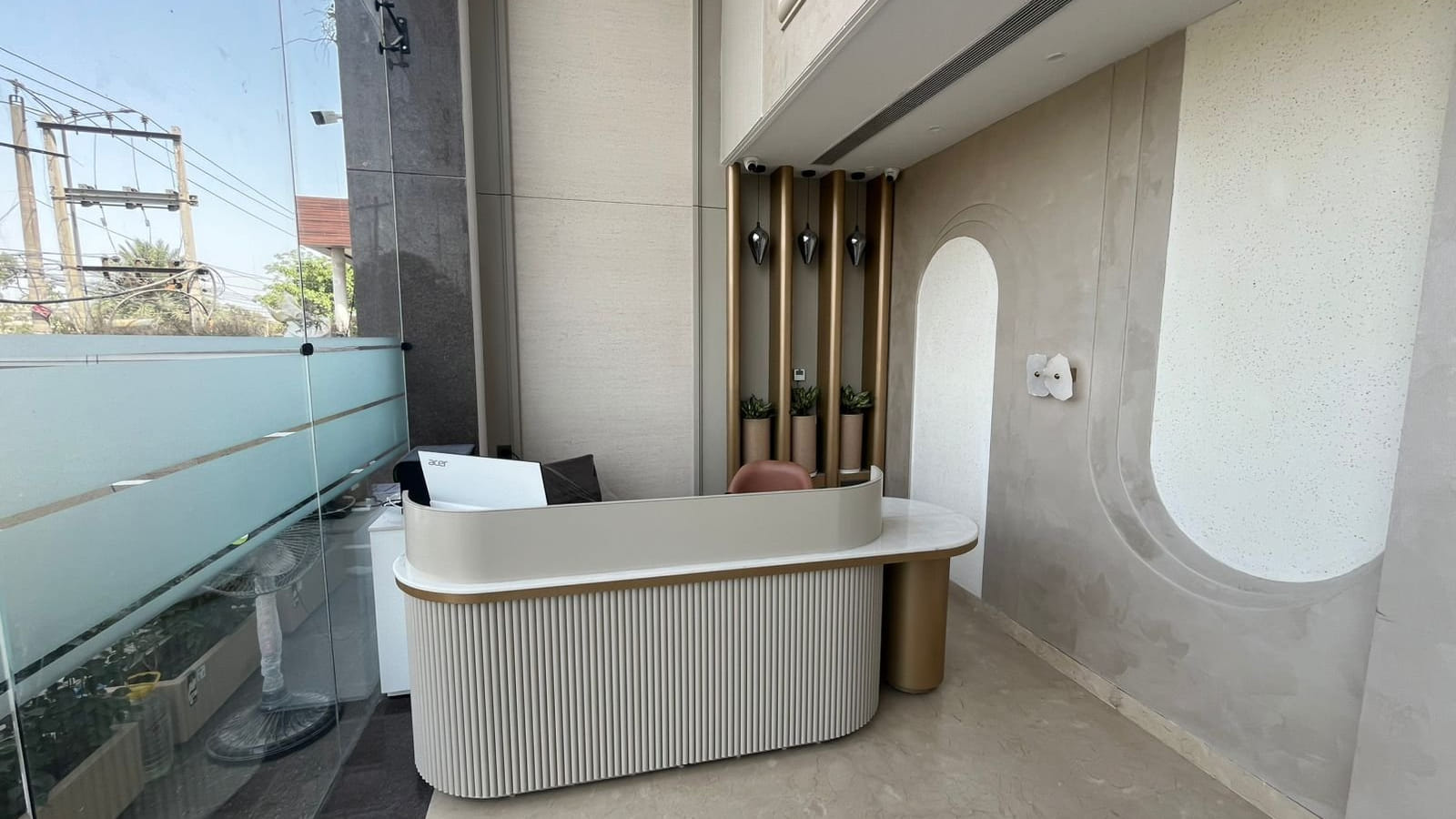 The terrace counter at Amara Portico, its fluted face and gold posts standing behind a glass balustrade above the street