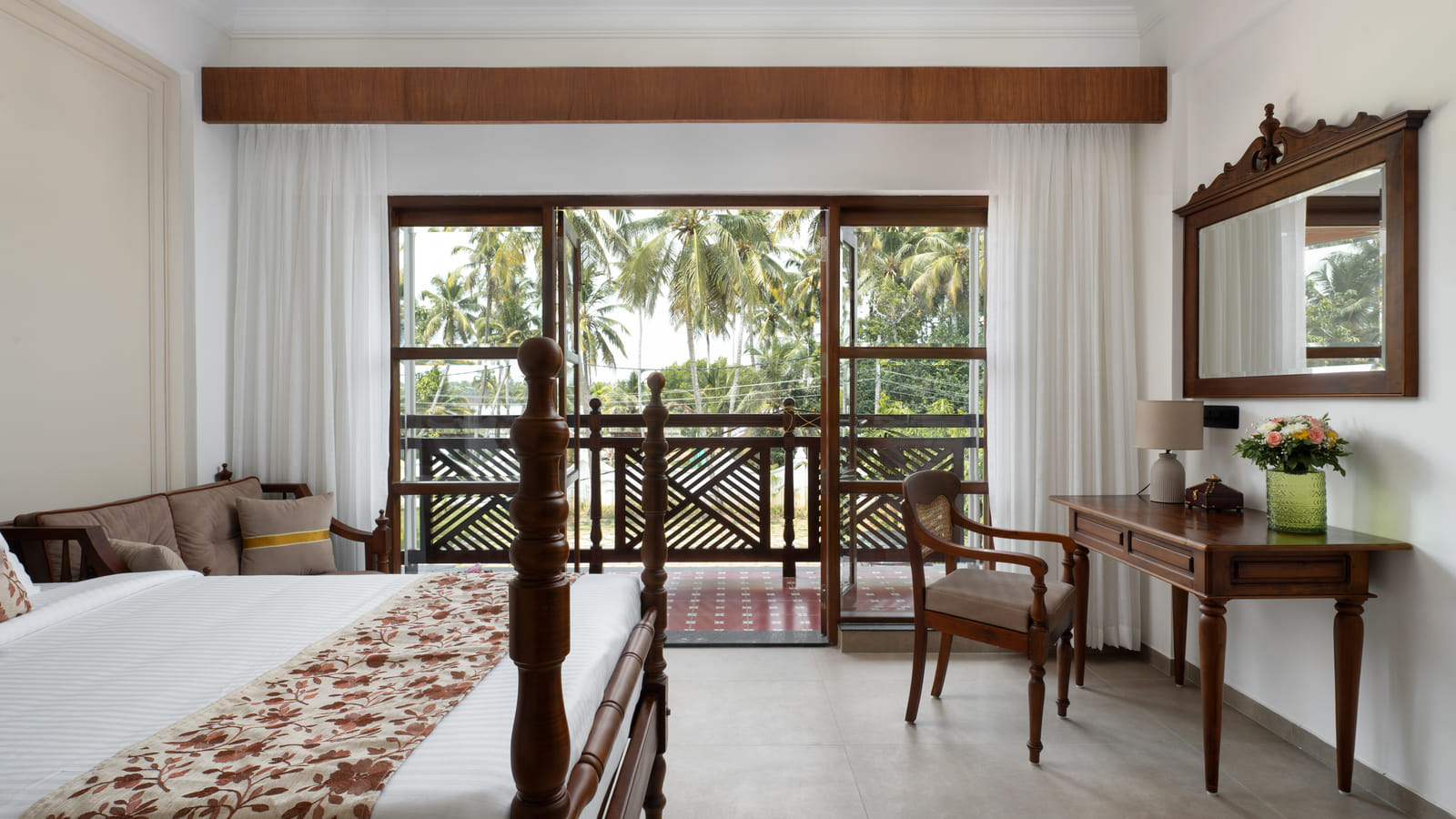 Garden View Room balcony corner with a writing desk, cushioned chair and open doors onto the garden, Sanskreti