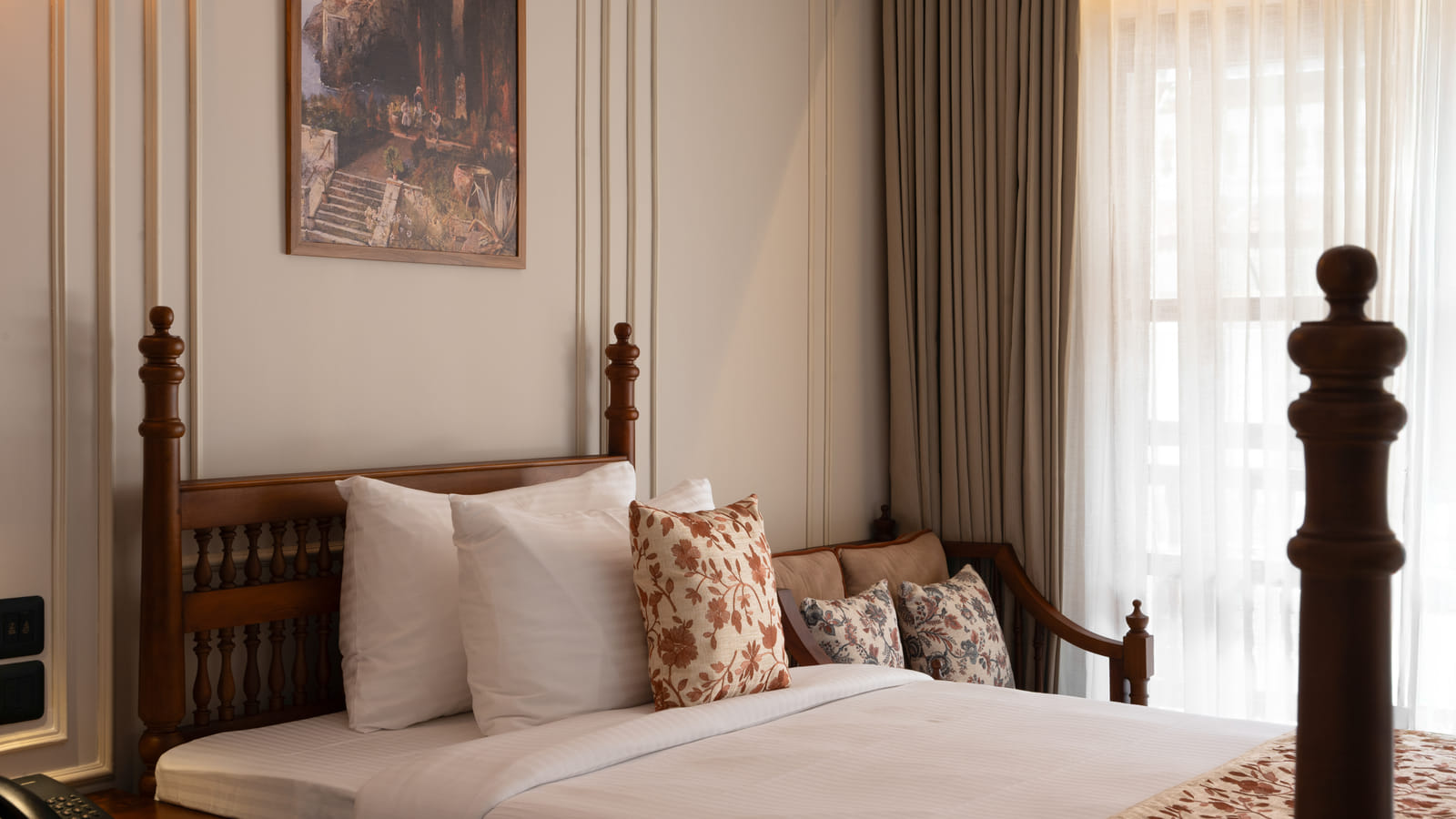 Close-up of a Garden View Room twin bed with cane headboard, patterned pillows and bedside lamp, Sanskreti