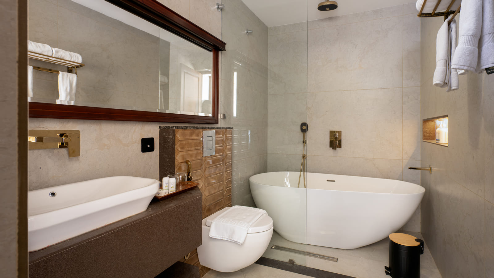 Heritage Suite bathroom with a freestanding deep-soaking bathtub beside stone-tiled walls and a rain shower, Sanskreti