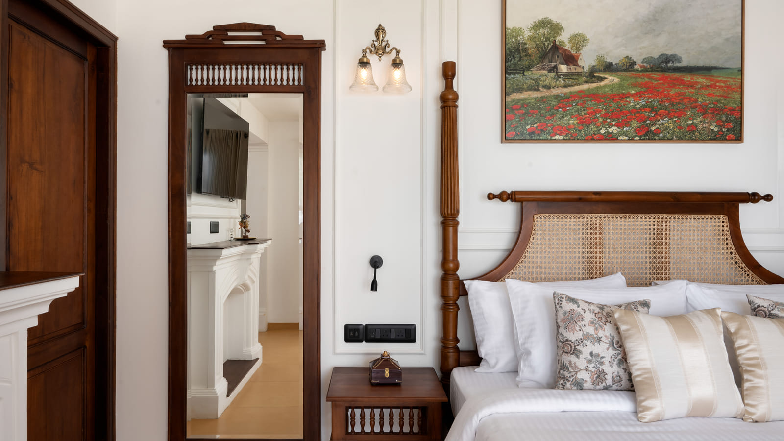 Close-up of the cane-woven headboard, bolster pillows and bedside lamp in the Heritage Suite, Sanskreti
