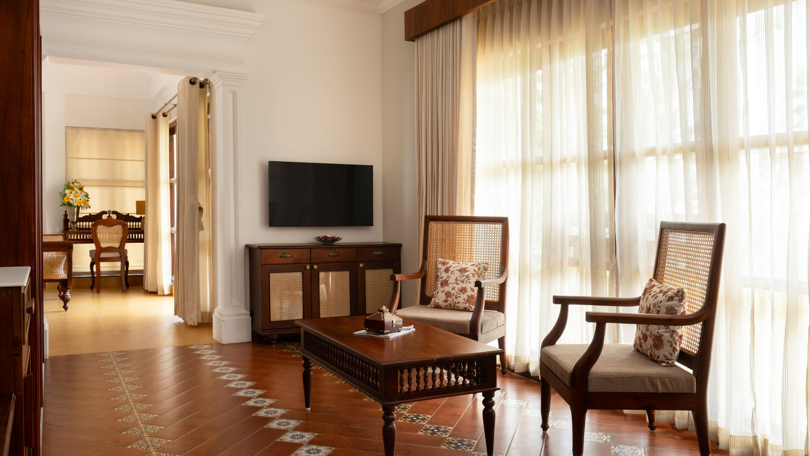 Heritage Suite living room with upholstered sofa, armchairs, coffee table and traditional Kerala wall art, Sanskreti