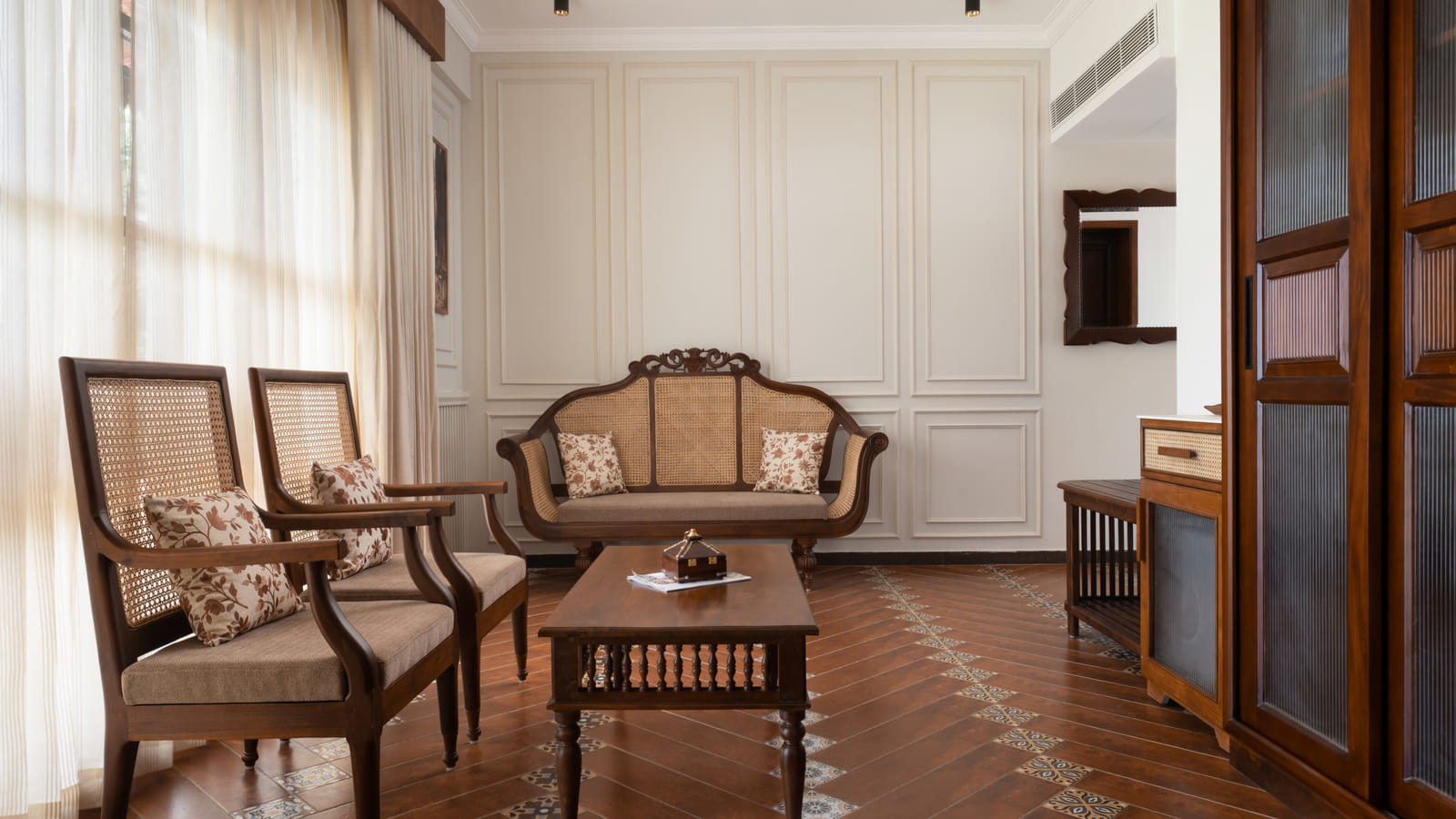 Heritage Suite seating area with a sofa, cushioned armchair and floor lamp beside a framed wall painting, Sanskreti