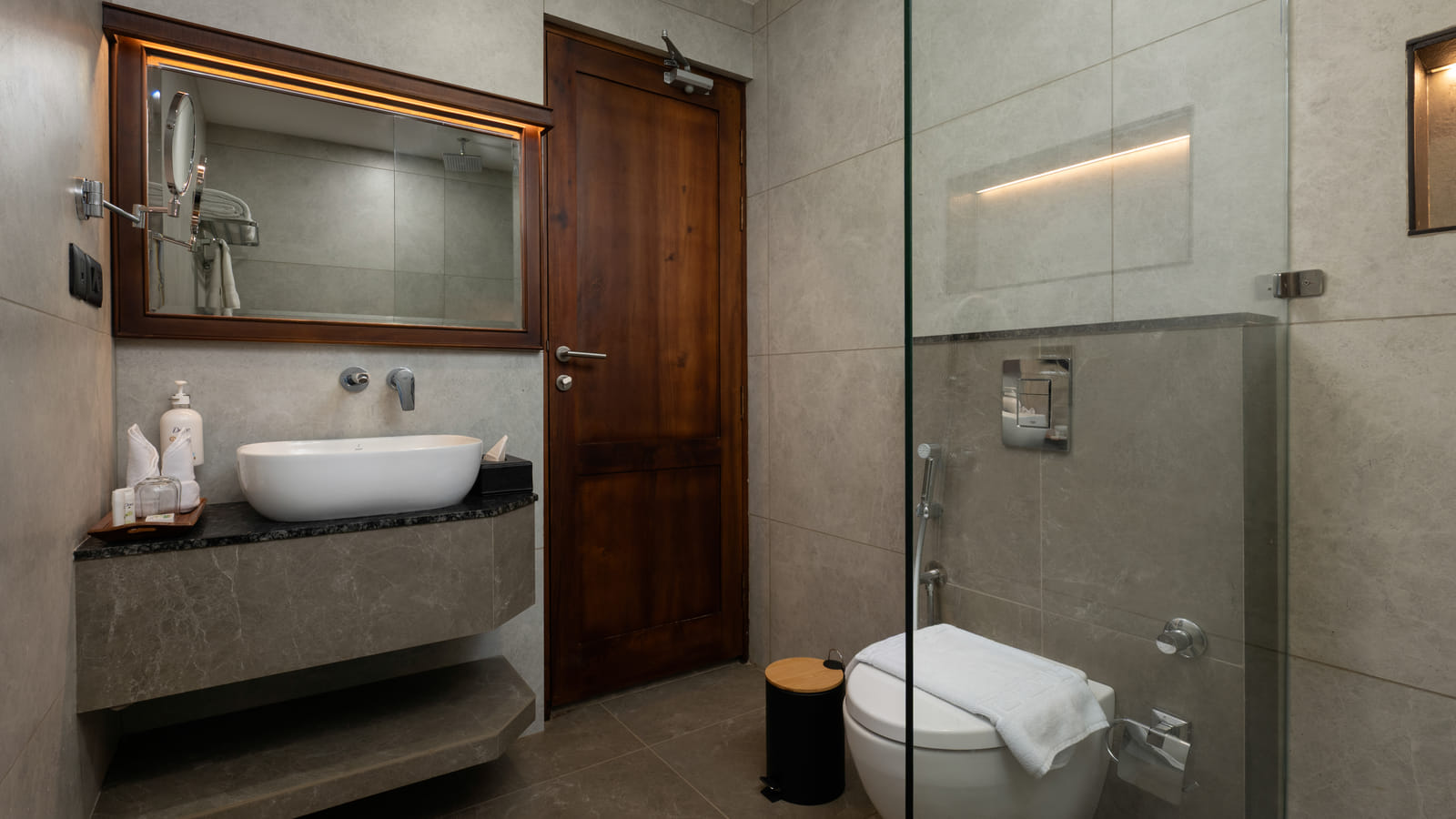 Pool View Room bathroom with stone-tiled shower cubicle, wooden vanity counter and framed mirror, Sanskreti