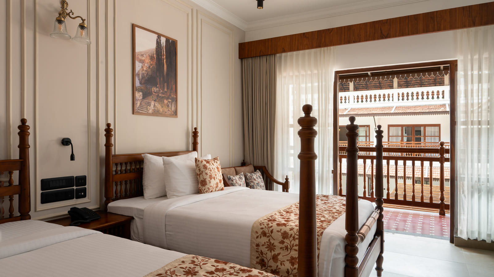 Pool View Twin Room twin beds facing open balcony doors that frame the outdoor pool and palms, Sanskreti