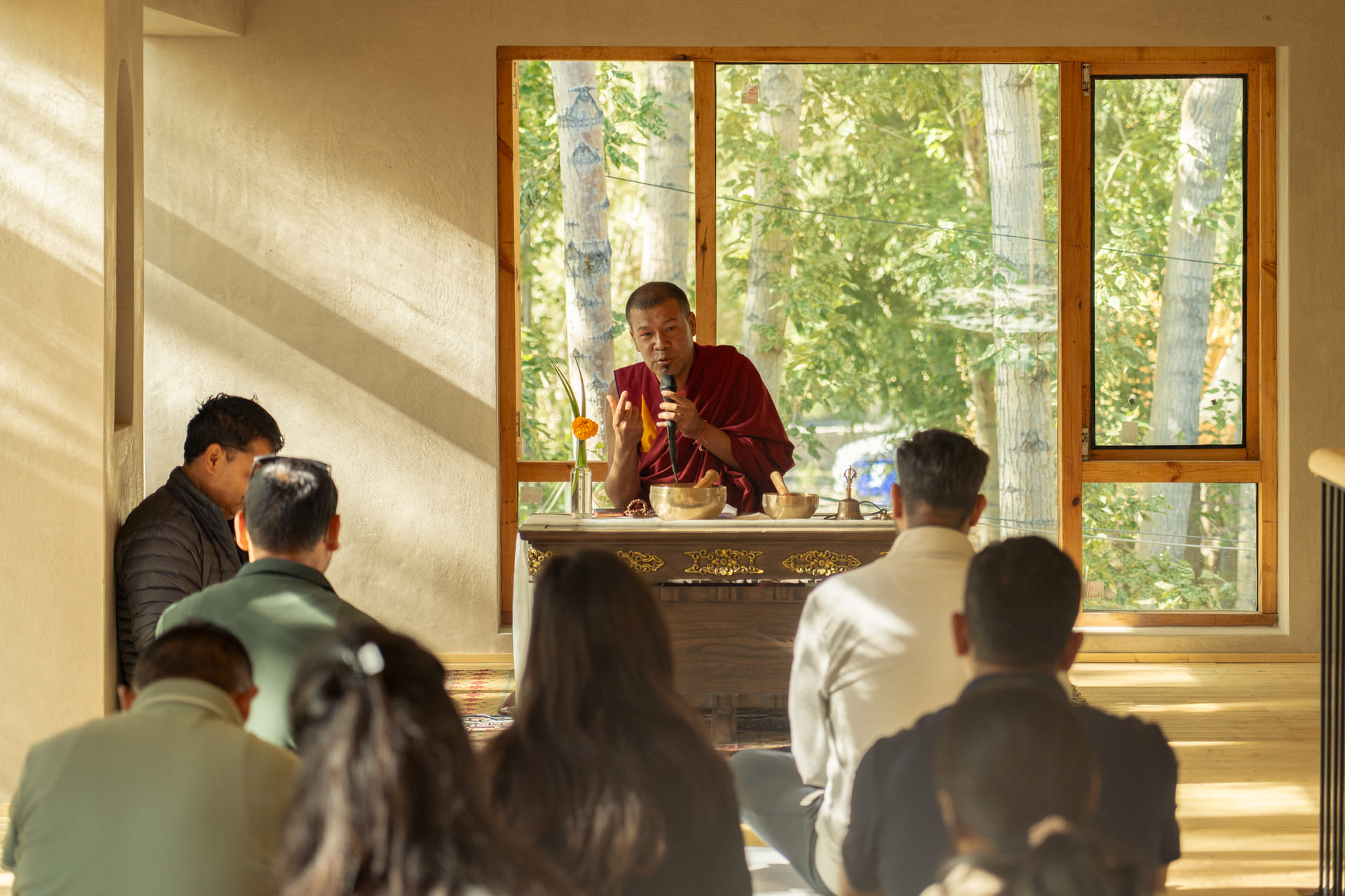 A learned monk leading a mindfulness session for seated guests at Stonehedge