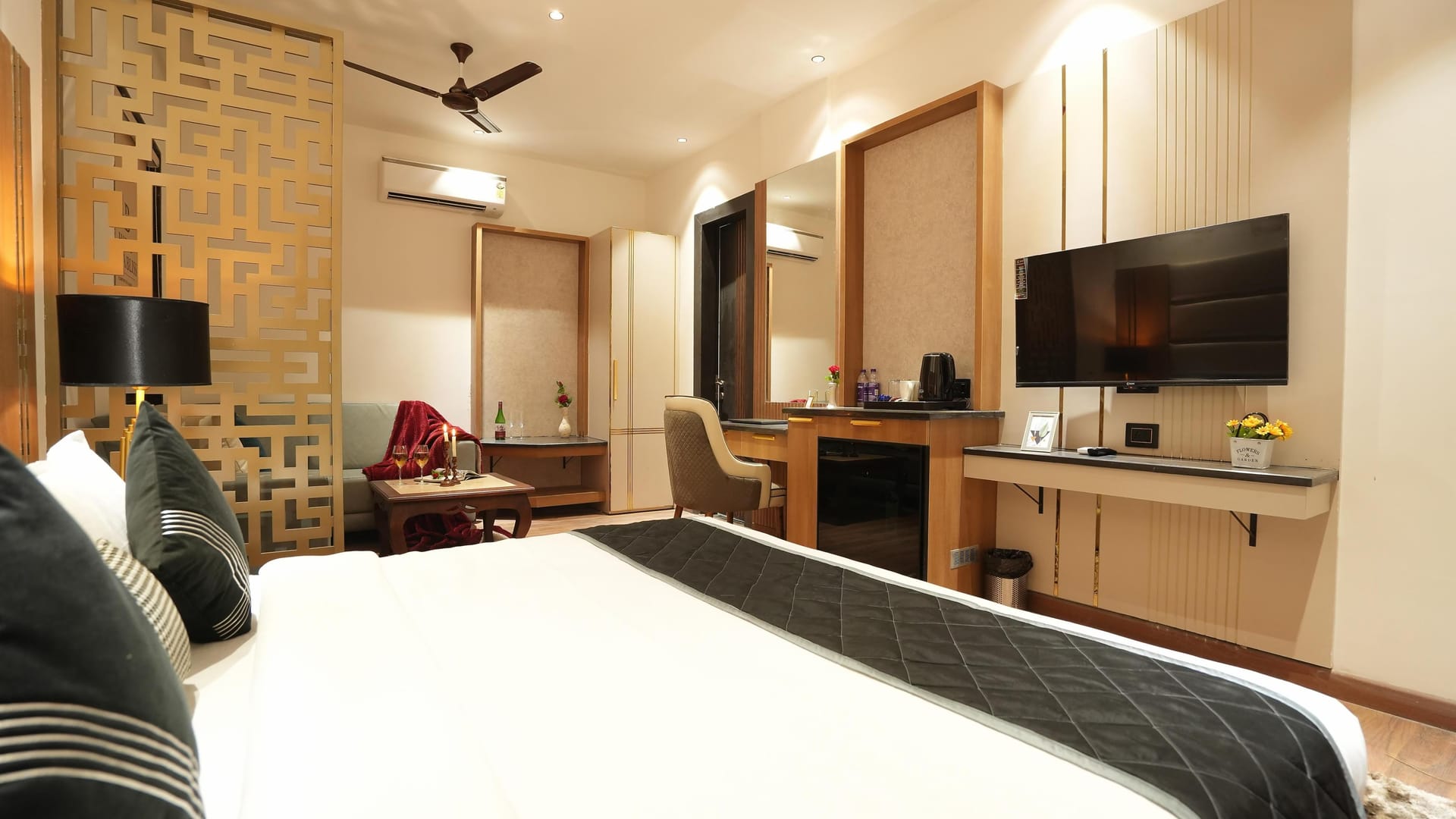 A Suite at Aura Bliss, with a carved gold screen dividing the room, a wall-mounted television