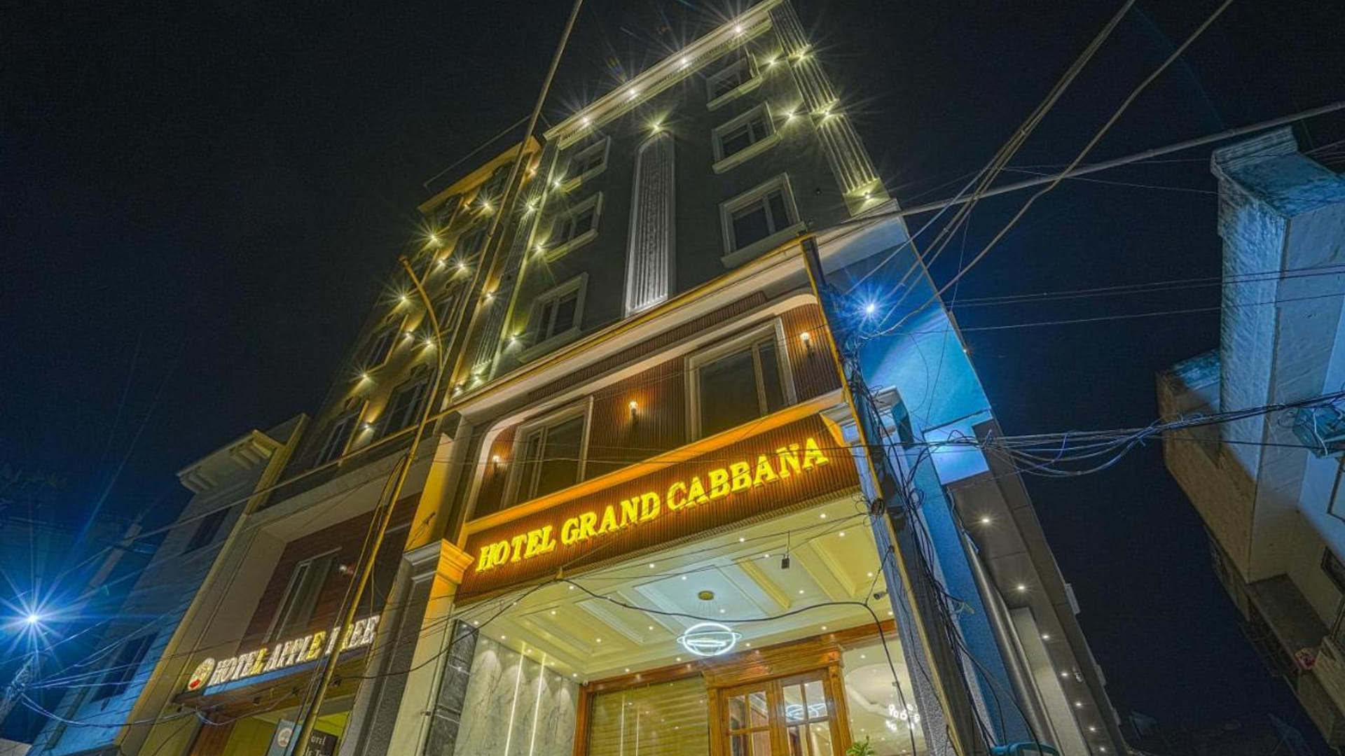 Grand Cabbana lit at night, the illuminated signage above the entrance