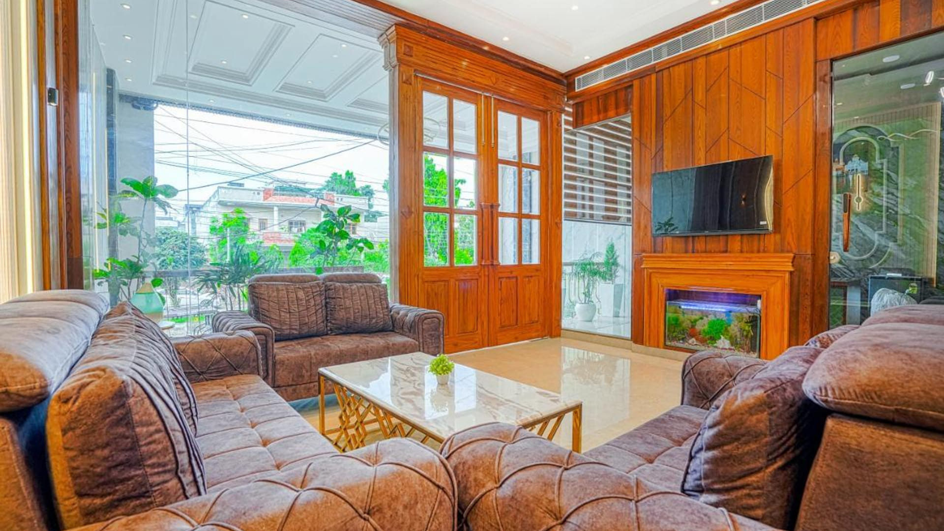 The lobby lounge at Grand Cabbana, with brown leather sofas around a low table, a wall-mounted television