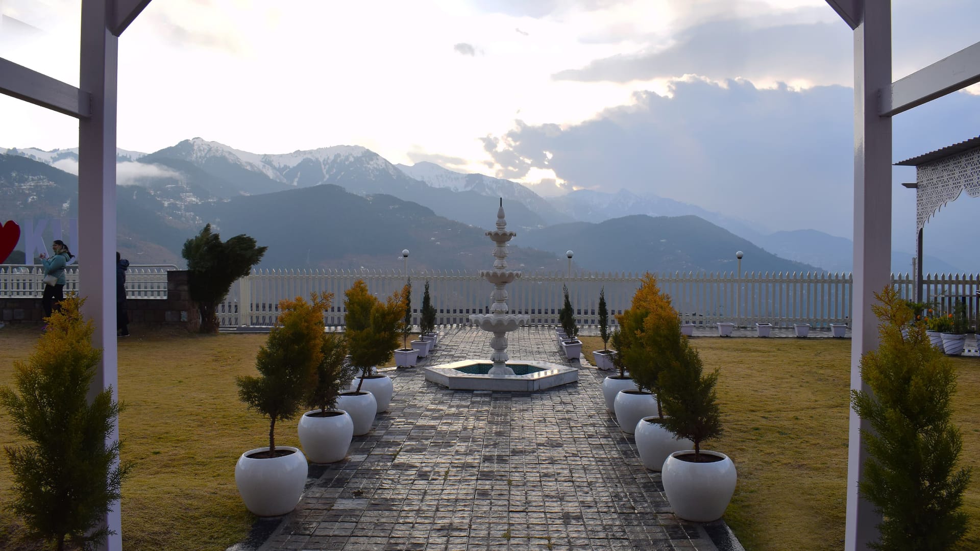 The lawn and fountain at Levelup The Heritage Kud in Patnitop, seen from under the pergola