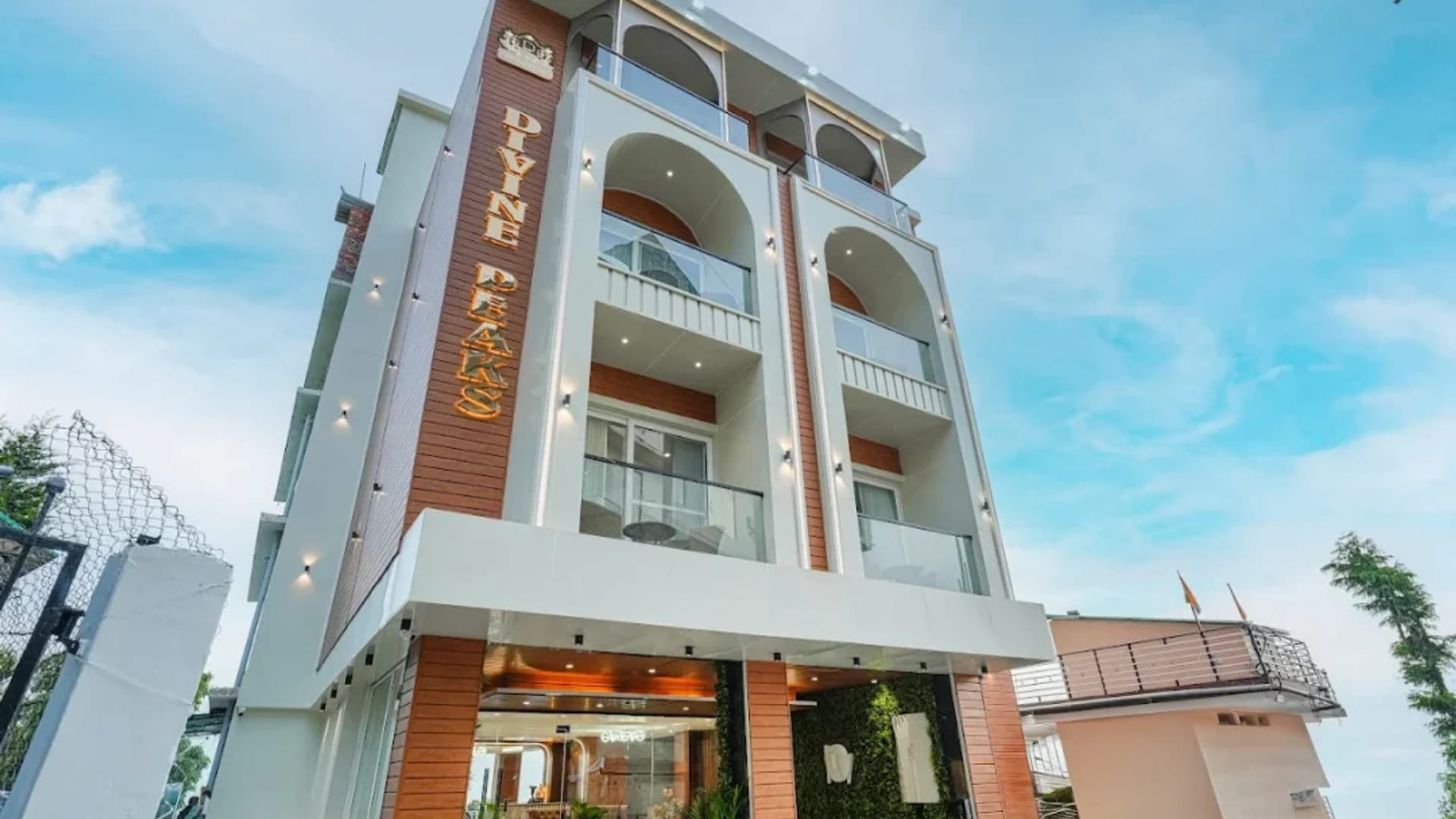 The white multi-storey exterior of White Panda Hotel Divine Peaks in Naddi, its balconies stacked above the entrance