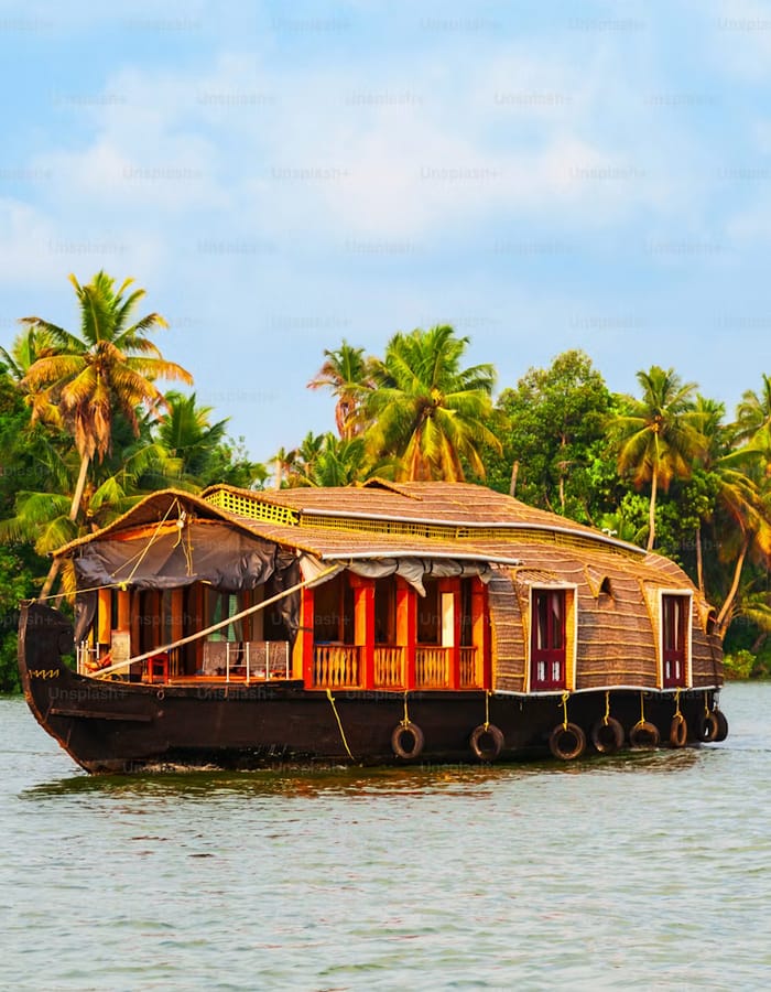 Open wooden country boat with a thatched canopy on the still Kumbalanghi backwaters