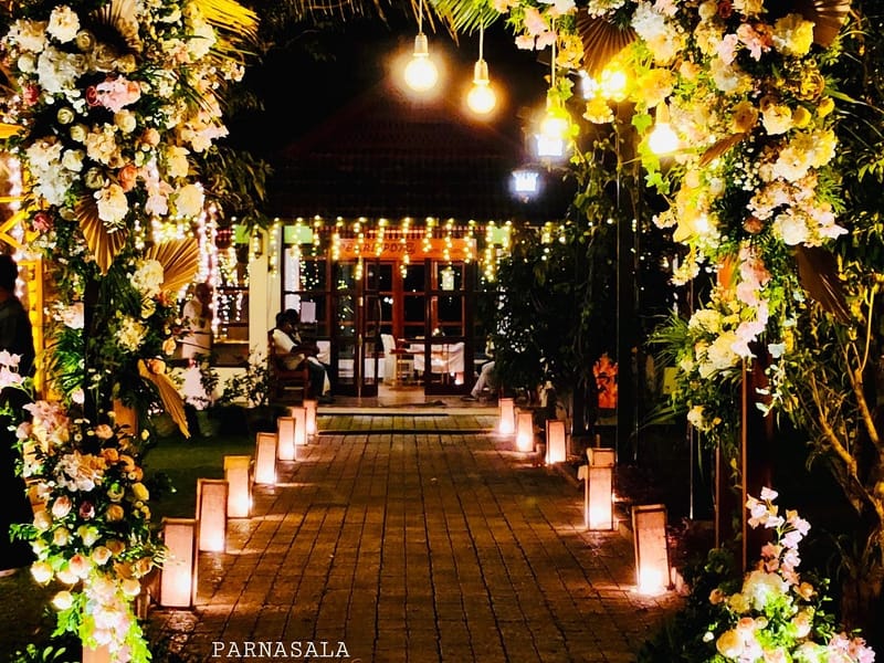 Outdoor courtyard pavilion at Sanskreti dressed with white drapes, floral pillars and traditional lamps for a wedding