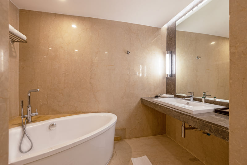 The Anya Suite bathroom with freestanding bathtub at The Anya Hotel, Gurugram