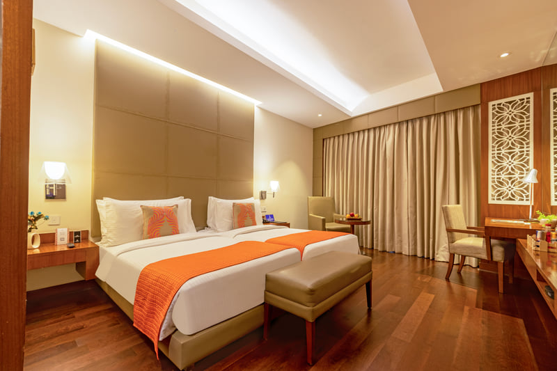 Deluxe Room king bed with bench at The Anya Hotel, Gurugram