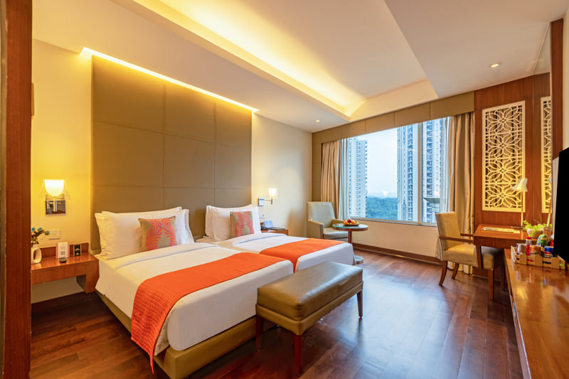 Deluxe Room twin beds with bench at The Anya Hotel, Gurugram
