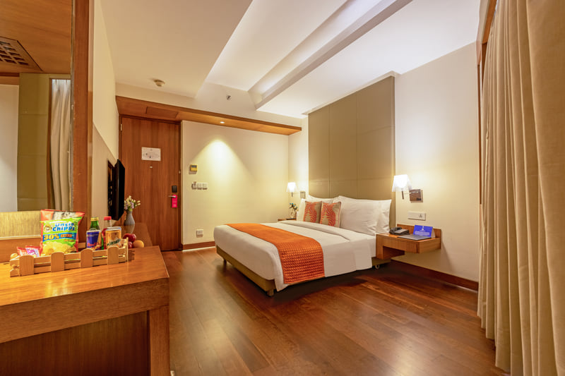 Standard King Room bed and minibar at The Anya Hotel, Gurugram