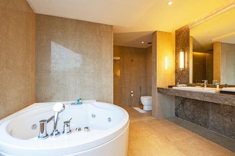 Studio Suite bathroom with jacuzzi at The Anya Hotel, Gurugram
