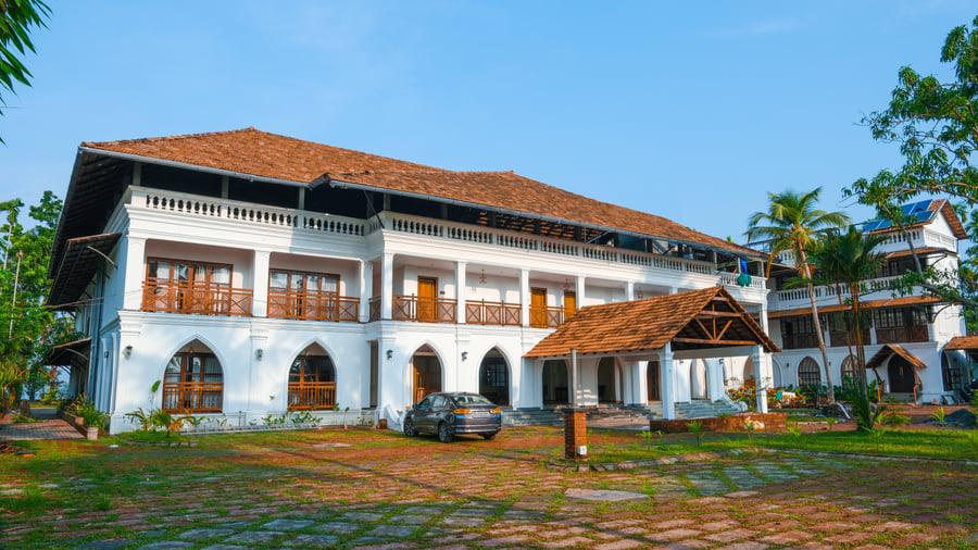 Sanskreti courtyard with arched white verandahs, terracotta-tiled roofs and a landscaped garden, Kumbalanghi, Kochi