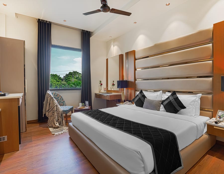 A Deluxe room at Aura Bliss, with a fluted headboard, bedside tables either side of the bed