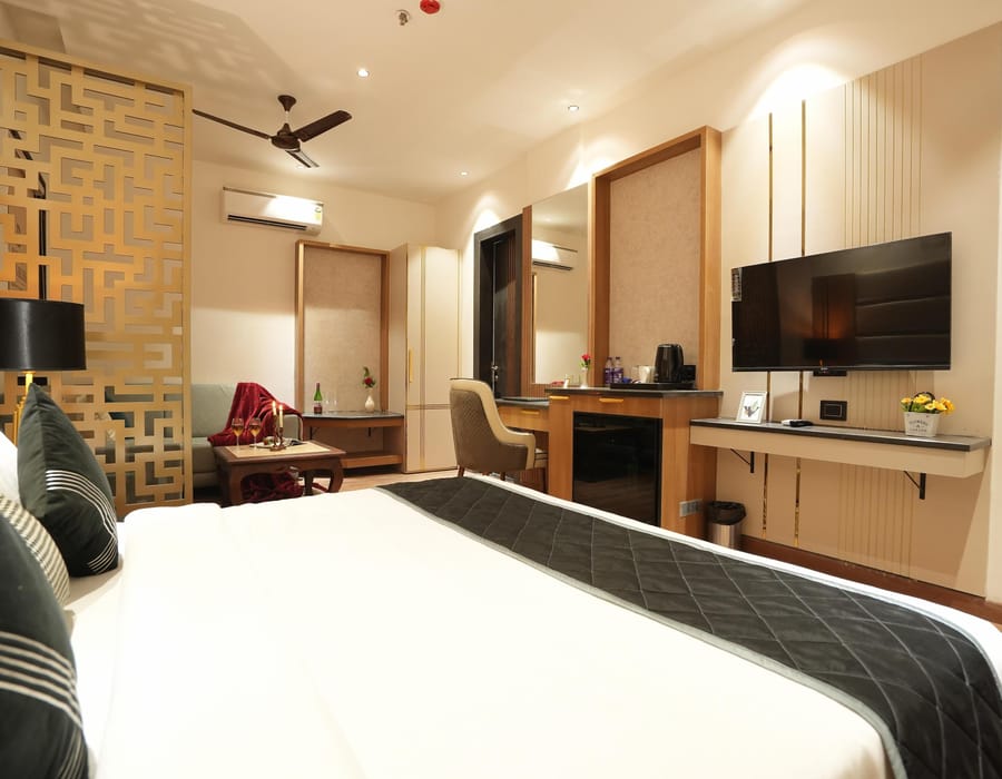 A Suite at Aura Bliss, with a carved gold screen dividing the room, a wall-mounted television