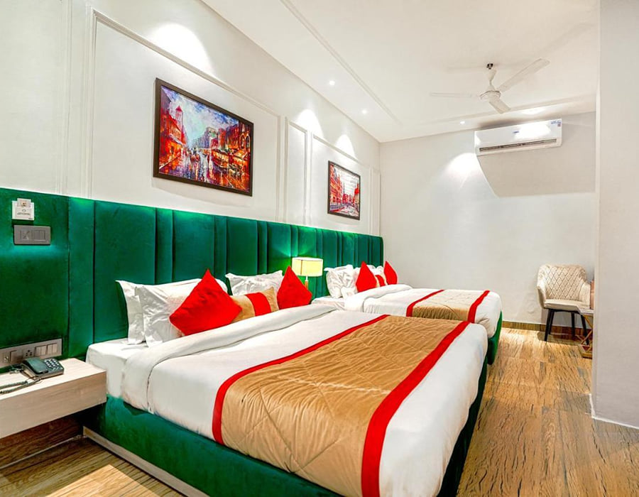 A Family Room at Grand Cabbana, with a green padded headboard, red cushions, a ceiling fan