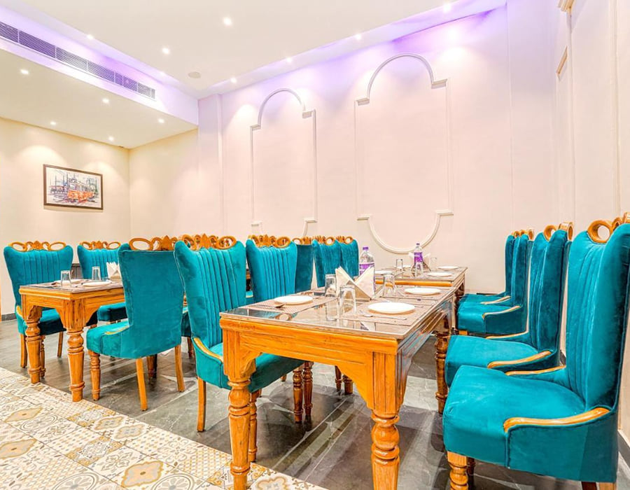 Cabbana Cafe at Grand Cabbana, with tables laid across the dining room between teal high-backed chairs