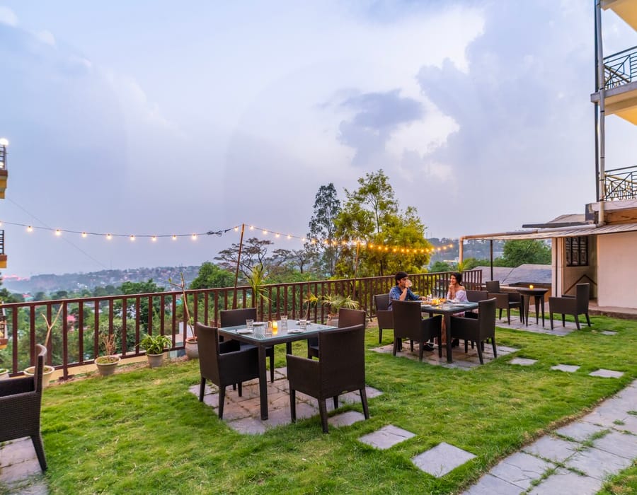 Outdoor dining on the lawn at Hotel Karnika, with tables and chairs set under strings of lights