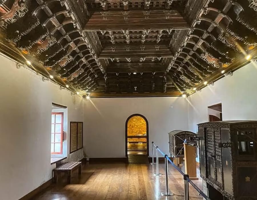 Whitewashed façade of the Mattancherry Dutch Palace with sloping tiled roof and arched entrance, Kochi