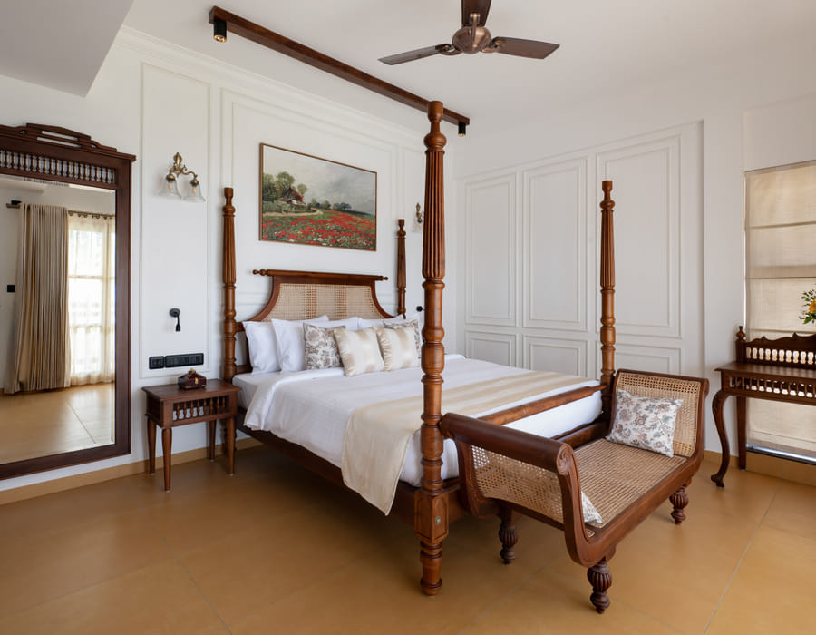 Heritage Suite four-poster king bed with cane headboard, floral runner and a large poppy-field wall painting behind