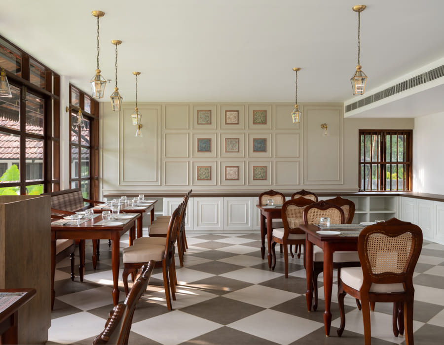 Long linen-draped dining table with place settings and warm pendant lamps at The Lilly's, Sanskreti, Kumbalanghi