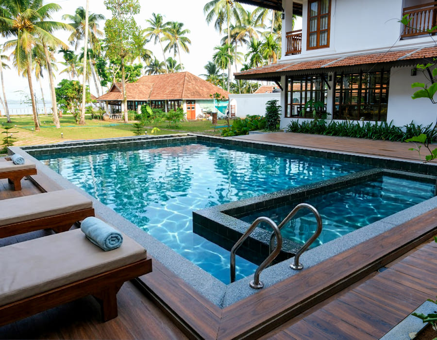 Sanskreti main pool and adjoining kids' pool with white loungers and coconut palms around the deck, Kumbalanghi