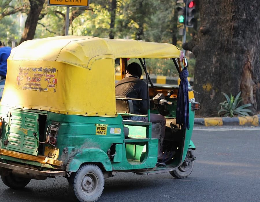 Yellow-and-black auto-rickshaw parked on a quiet heritage lane in Fort Kochi, Kochi