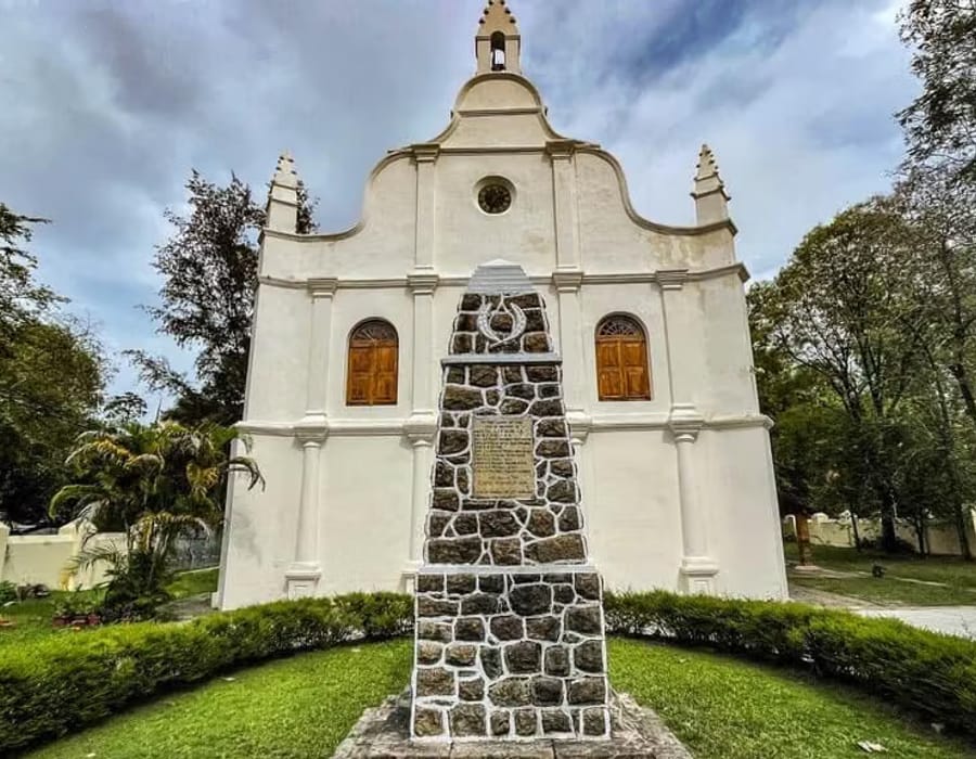 Whitewashed façade of St. Francis Church with a stepped gable and central cross, Fort Kochi